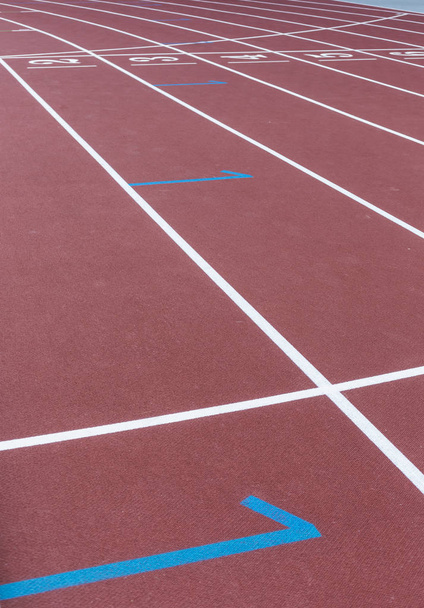 rote Sportstrecke für das Laufen auf Stadionstartmarkierungen. ein Konzept für einen gesunden Lebensstil. Sport Hintergrund abstrakte Textur - Foto, Bild