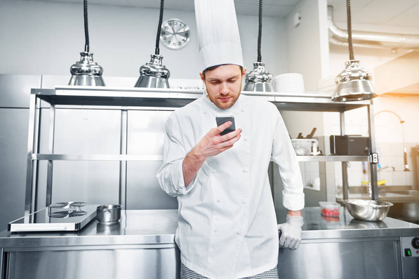 chef cook with smartphone at restaurant kitchen - 写真・画像