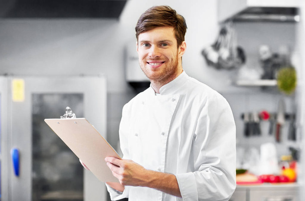chef with clipboard doing inventory at restaurant - Photo, Image