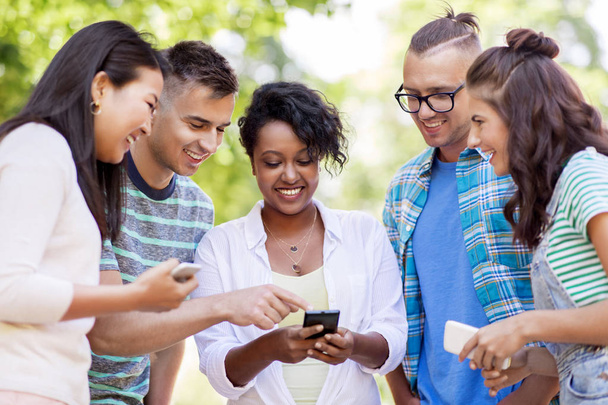 group of happy friends with smartphone outdoors - Photo, Image