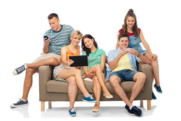 amis avec tablette PC et smartphones assis sur le canapé
 - Photo, image