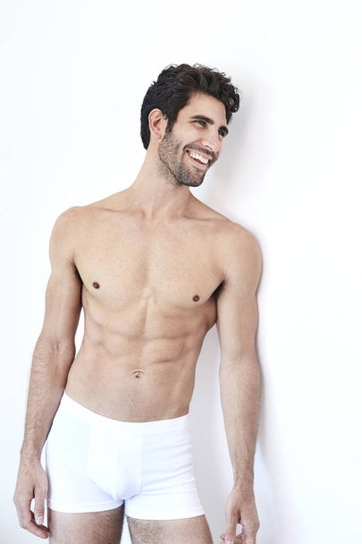 Smiling guy in white shorts standing in studio - Foto, Bild