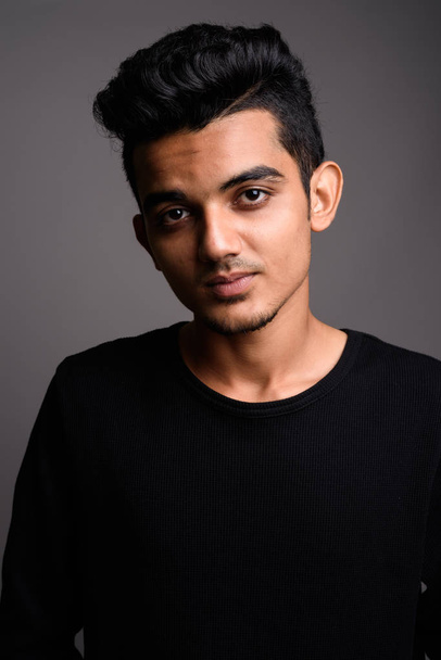 Young Indian man against gray background - Foto, Bild