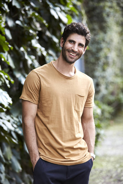 Smiling guy in t-shirt, looking away outdoors  - Foto, Imagen