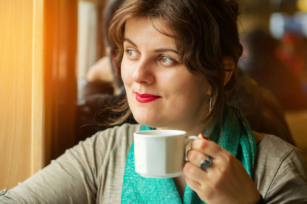 Sogno e sorridente giovane donna in possesso di una tazza di tè
 - Foto, immagini
