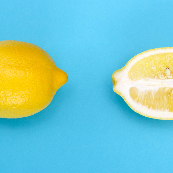 U snijdt langs een stuk van gele citroen en een hele gele citroen - Foto, afbeelding