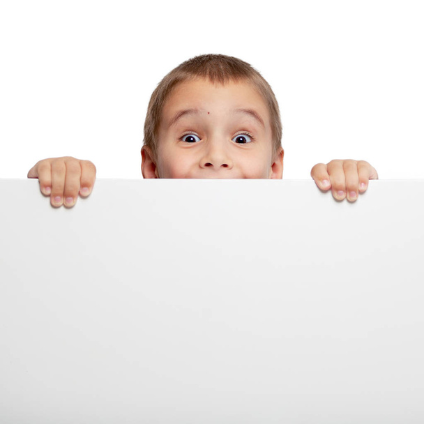 Banner with a surprised child peeking at the edge. Photo on a white background - Foto, afbeelding