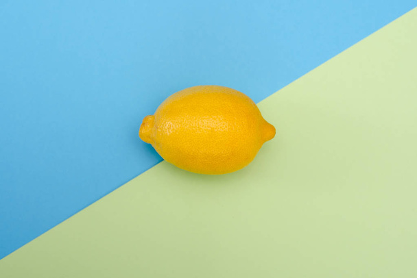Un citron jaune sur fond vert-bleu
 - Photo, image