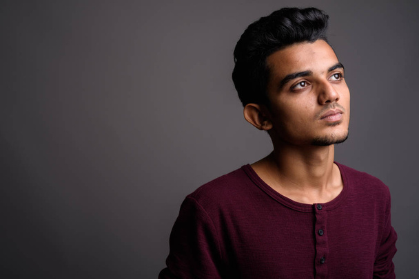Jonge Indiase man tegen een grijze achtergrond - Foto, afbeelding