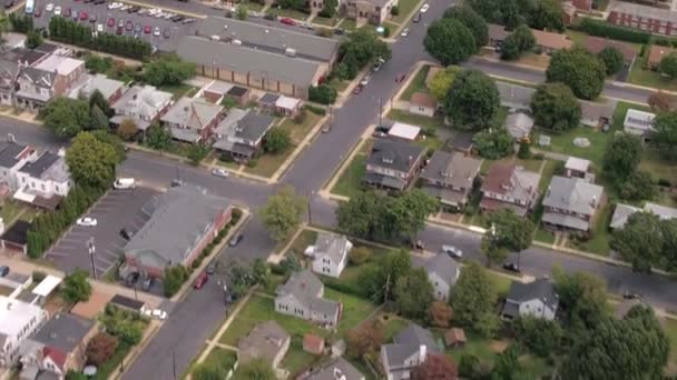 AERIAL: Flying above colorful rooftops and empty streets of quiet luxury subdivision suburban town. Rows of identical twin houses, parking lots and several cars parked on the road on cloudy autumn day - Footage, Video