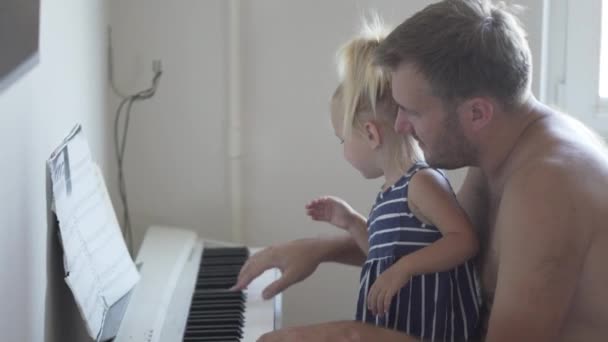 Papa spielt mit seiner kleinen Tochter Klavier - Filmmaterial, Video