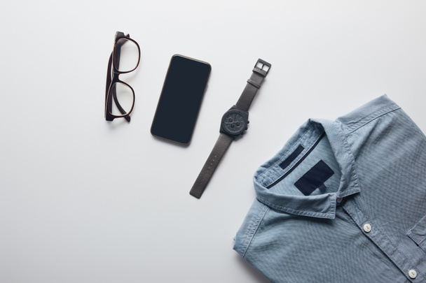 Draufsicht auf Hemd, Smartphone und Brille isoliert auf Weiß - Foto, Bild