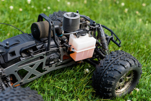 Radio-controlled car with internal combustion engine for nitro fuel, with one cylinder, standing on green grass. - Φωτογραφία, εικόνα