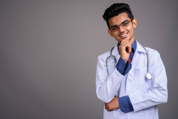 Young Indian man doctor against gray background - Photo, Image
