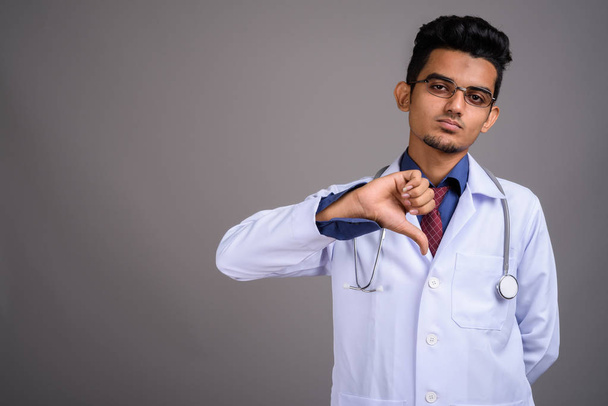 Genç Hintli adam doktor gri bir arka plana dayanır - Fotoğraf, Görsel