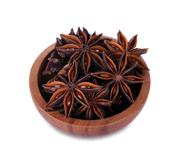 Estrela chinesa anis semente em estrela chinesa anis semente em tigela de madeira sobre o fundo branco
 - Foto, Imagem