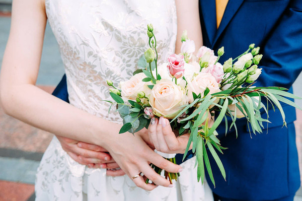 Muž a žena v modrém obleku a svatební šaty stále ženatý a drží ruce - Fotografie, Obrázek