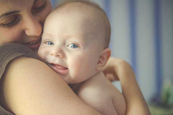 Mom hugs a newborn baby and smile - Valokuva, kuva