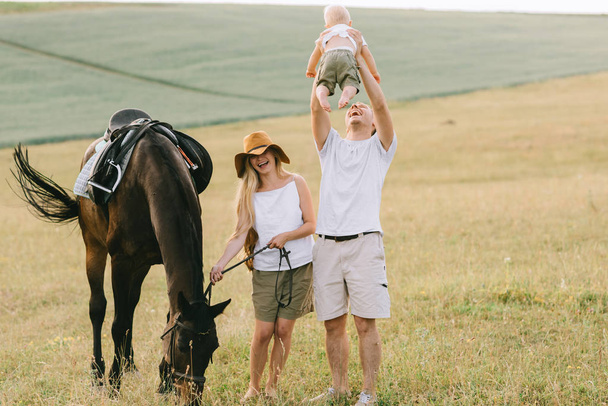 young family have a fun in the field. Parents and child with a horse in the field  - Foto, immagini