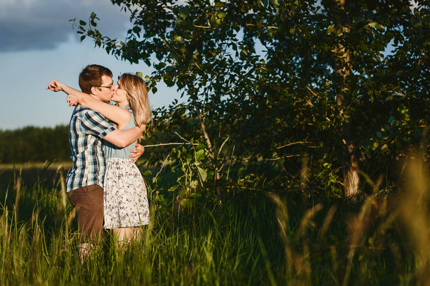 young man and woman are Kissning at sunset in summer - Foto, Imagen