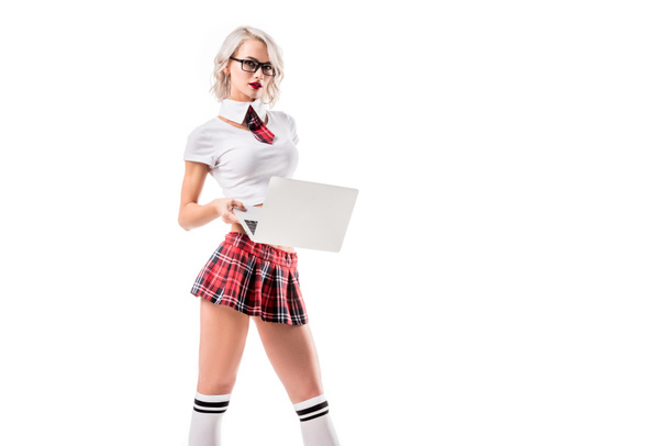 fiatal nő csábító iskoláslány egyenruhában, látszó-on fényképezőgép, elszigetelt fehér laptop - Fotó, kép