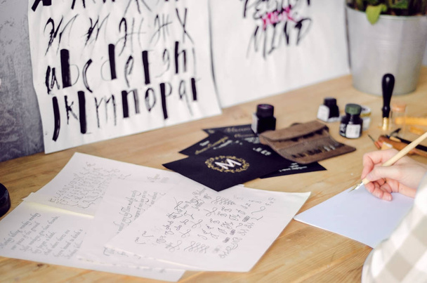 Dessins calligraphiques avec aquarelle sur le bureau des calligraphes. Outils et œuvres de l'artiste
. - Photo, image