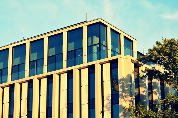 Современный фасад офисного здания абстрактный фрагмент, блестящие окна в стальной конструкции, ретро стилизованный красочный тональный фильтр
 - Фото, изображение