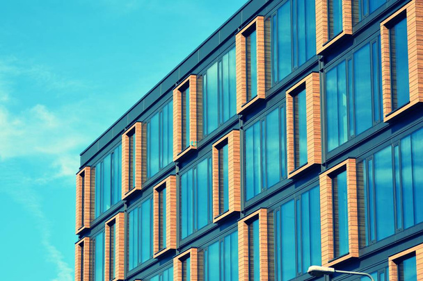 Современный фасад офисного здания абстрактный фрагмент, блестящие окна в стальной конструкции, ретро стилизованный красочный тональный фильтр
 - Фото, изображение