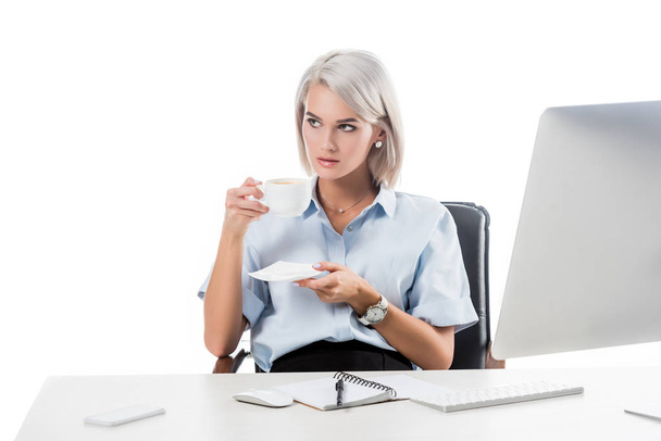 Portret van zakenvrouw met kop koffie op werkplek met laptop en computer scherm geïsoleerd op wit - Foto, afbeelding