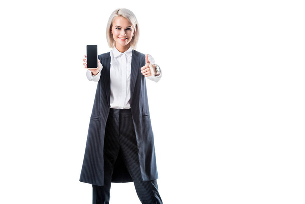 femme d'affaires souriante montrant pouce levé et smartphone avec écran blanc isolé sur blanc
 - Photo, image