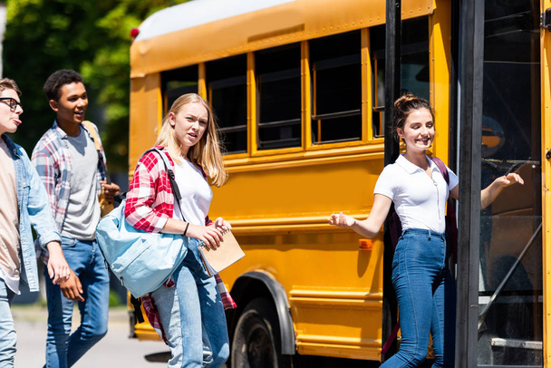 grupo de adolescentes alunos entrando ônibus escolar após as aulas
 - Foto, Imagem