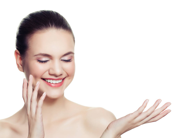健康な女性のスパ モデルの笑顔と、白い背景で隔離の開いた手に空のコピー領域が表示。スキンケアとウェルネスのコンセプトです。お使いの製品を提示 - 写真・画像