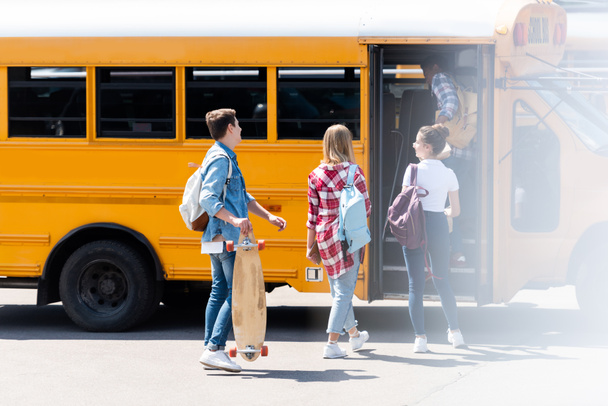 grupo de estudiantes adolescentes caminando dentro del autobús escolar
 - Foto, imagen