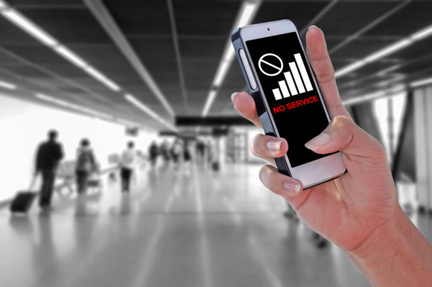 Hombre usando el teléfono inteligente NO SERVICE en el aeropuerto y fondo borroso con ruta de recorte en el panel de pantalla
 - Foto, imagen