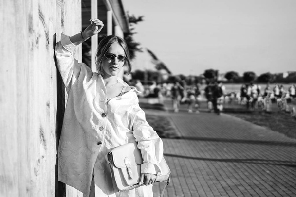 Monochrome view of stylish woman posing outdoor near wooden wall. - Valokuva, kuva
