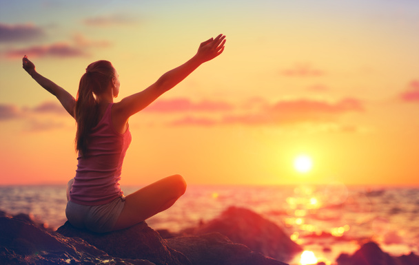 Relaxace a jóga při západu slunce - dívka s otevřenou náručí pohledu oceán - Fotografie, Obrázek
