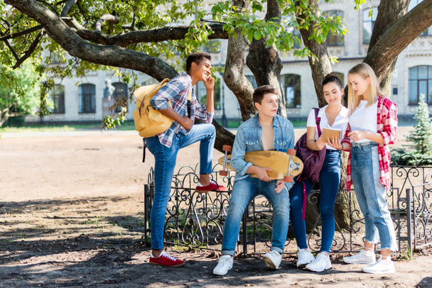 Gruppe Jugendlicher sitzt zusammen im Schulgarten - Foto, Bild