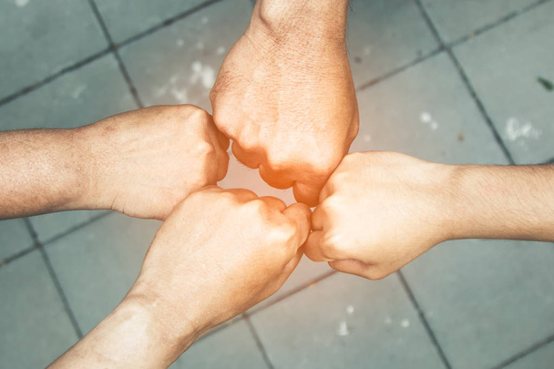 Begrip "teamwork"; veel mensen staan en touch handen samen in veld voordat u begint competitie spel - Foto, afbeelding