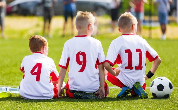 Football soccer game for children. Kids substitute players sitting on a bench. Football sports tournament for young boys - Fotoğraf, Görsel