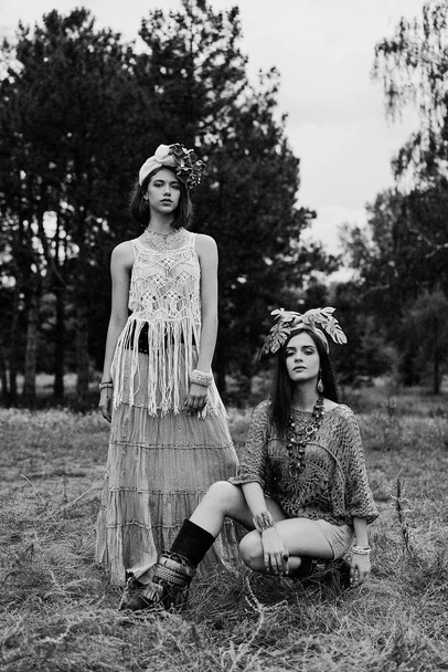 two beautiful young women in elegand headdresses posing outdoors - Photo, Image