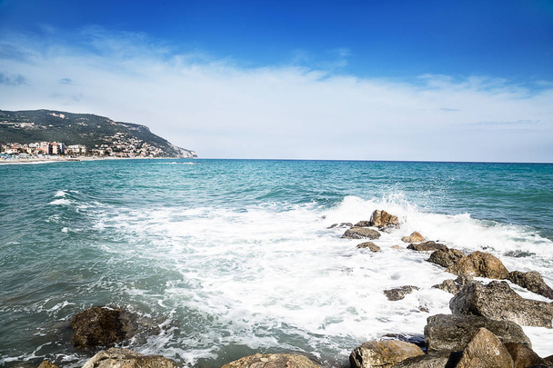 Pebble stones by the sea. Silky waves of blue sea. Summer beach background. Liguria, Italy. - Foto, Bild