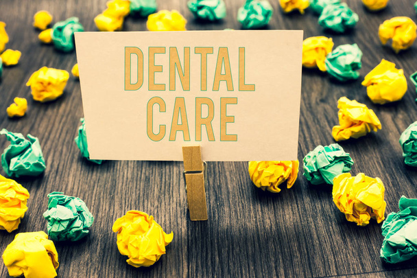 Handwriting text writing Dental Care. Concept meaning maintenance of healthy teeth or to keep it clean for future Clothespin holding light pink note paper crumpled papers several tries - Photo, Image