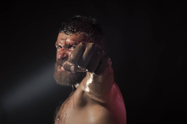 Fist with blood of bearded man on black background - Фото, зображення