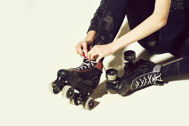 patines de ruedas en mujer o niña en cordones de corbata negra
 - Foto, imagen