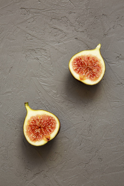 Two halves of a fig on gray background, top view. Overhead, from above. - Photo, Image