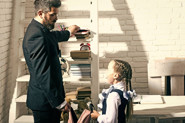 Education and family concept. Man and kid stand by shelf - Φωτογραφία, εικόνα