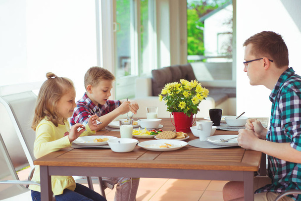 Happy young family having fun during breakfast on the big terrasse at home  - Fotoğraf, Görsel