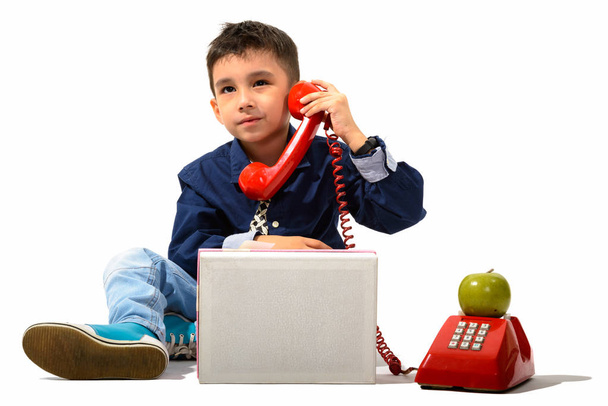 Studio shot of cute boy talking on old telephone while thinking - Foto, Imagem
