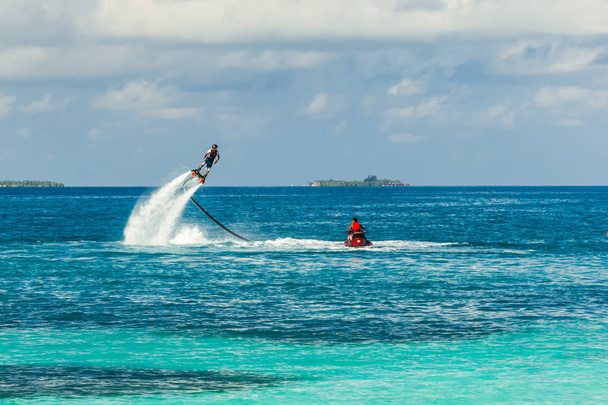 Extreme water sport background. Fly board in tropical sea, luxury vacation and luxury activities. Summer vacation or holiday sport background. Fly board and professional rider - Photo, Image