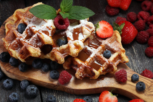 Traditional belgian waffles with fresh mint, sugar and raspberries, blueberries and strawberries - Fotoğraf, Görsel
